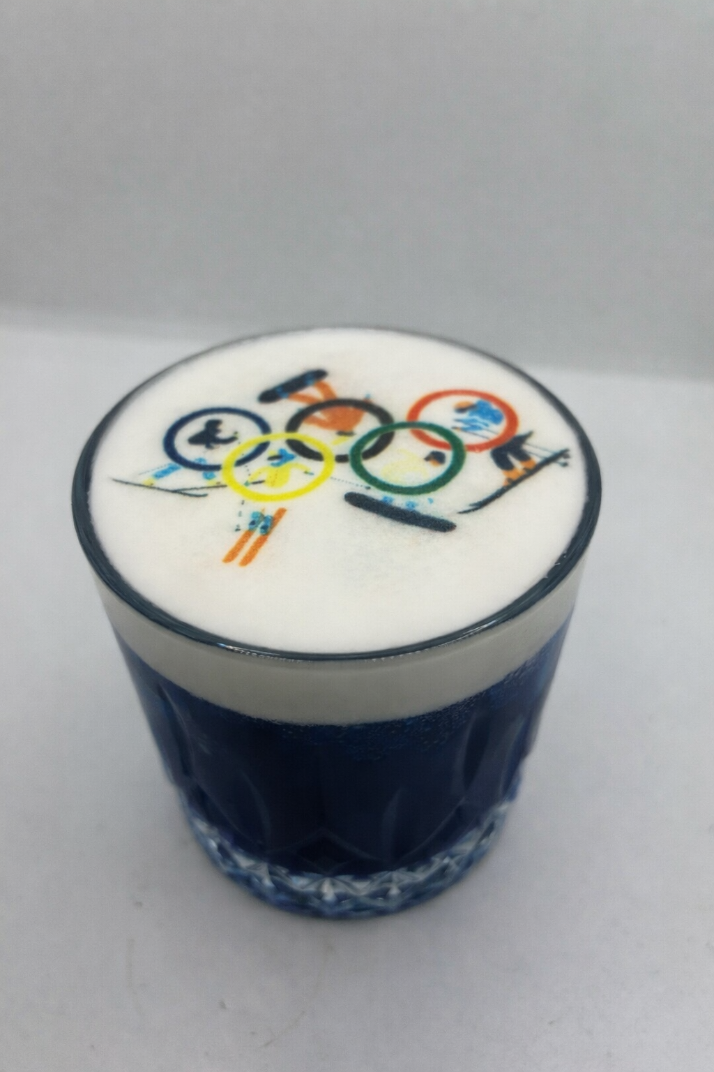 Cocktail bleu avec anneaux olympiques imprimés sur la mousse